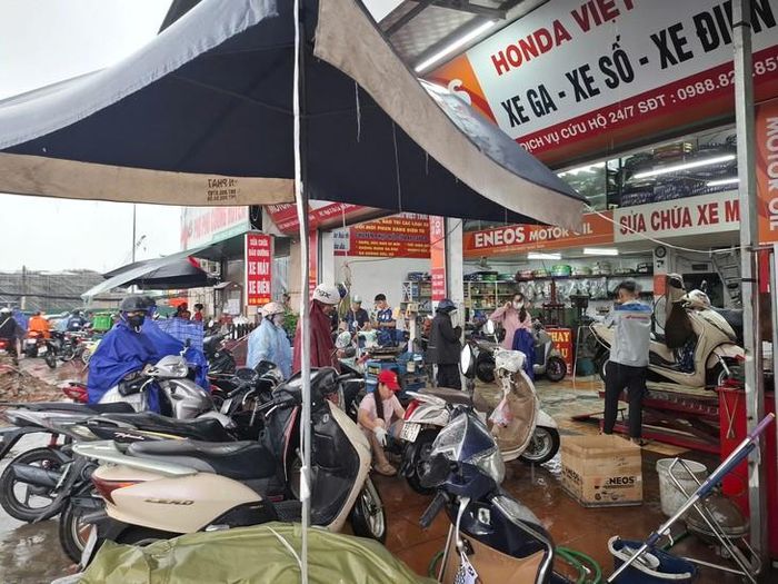 Người làm dịch vụ sửa xe máy làm "luôn chân luôn tay" không hết việc.