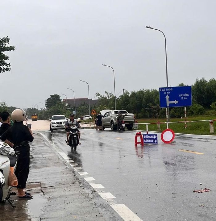 Lực lượng chức năng trực tại các điểm ngập, cảnh báo người dân không đi qua khu vực nguy hiểm. Ảnh: CTV.