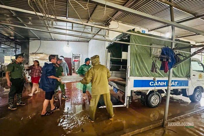 Cán bộ, chiến sĩ hỗ trợ người dân di chuyển tài sản khỏi vùng ngập. Ảnh: Công an Phú Thọ