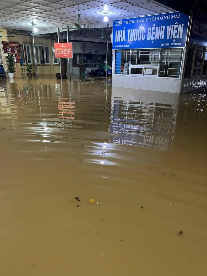 Nước lũ dâng cao, bao phủ khuôn viên và nhiều khu vực tầng 1 Trung tâm Y tế Hoàng Mai, gây khó khăn cho việc đi lại, điều trị và sinh hoạt. ẢNH: H.M