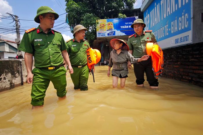 Công an xã Quảng Bị thăm hỏi người dân về tình hình an ninh trật tự khu vực ngập sâu