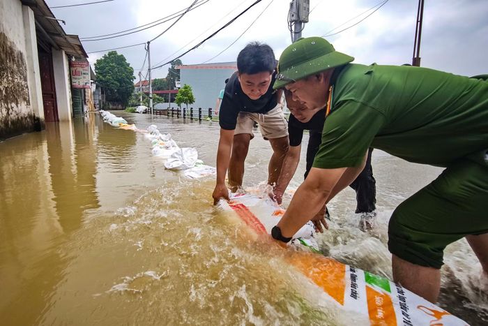 Công an xã Quảng Bị cùng nhân dân khẩn trương gia cố các đoạn bao cát ngăn nước tràn sang phía cánh đồng