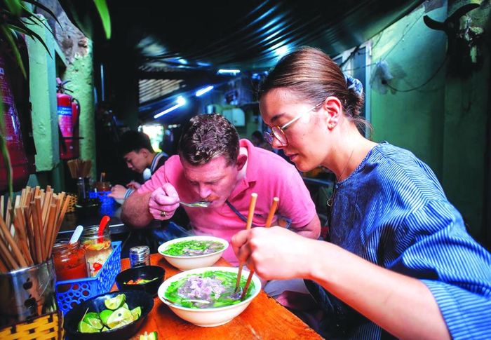 Du khách nước ngoài ăn phở Hà Nội.