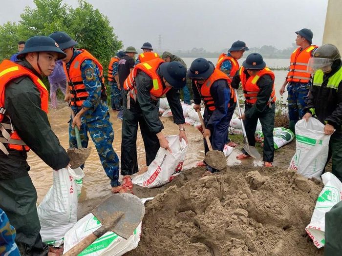 Các chiến sĩ xúc đất, vận chuyển vật liệu và gia cố từng vị trí trên bờ đê