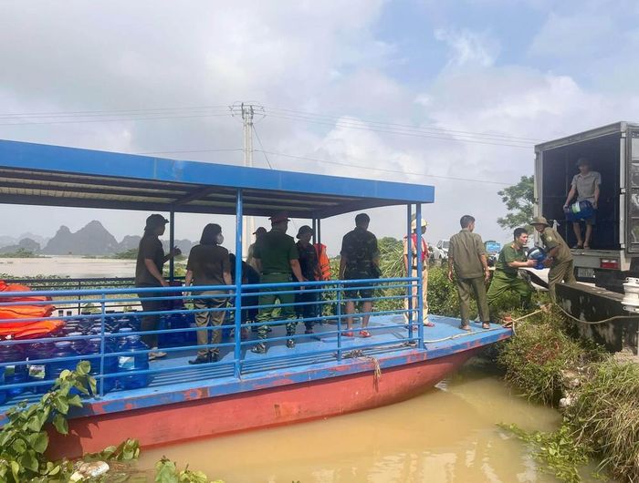 Lực lượng chức năng vận chuyển nước uống, nhu yếu phẩm hỗ trợ người dân tại khu vực ngập lụt thôn Kênh Gà, xã Gia Viễn, tỉnh Ninh Bình. Ảnh: Thùy Dung - TTXVN