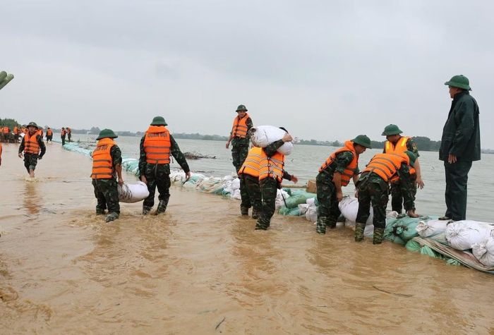 Lực lượng bộ đội đắp đê chống tràn tại xã Xuân Mai. (Ảnh NGỌC MAI)