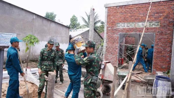 Cán bộ, chiến sĩ tích cực phối hợp các lực lượng tại chỗ triển khai xây mới, sửa chữa 125 căn nhà đúng tiến độ, bảo đảm chất lượng. (Ảnh: VĂN ÚT)