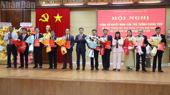 Các đồng chí lãnh đạo Ủy ban nhân dân tỉnh Đắk Lắk trao quyết định bổ nhiệm lãnh đạo Ban Quản lý các khu kinh tế và các khu công nghiệp Đắk Lắk và tặng hoa chúc mừng. (Ảnh: Công Lý)