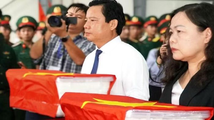 Phó Chủ tịch Ủy ban nhân dân tỉnh Tây Ninh Phạm Tấn Hòa (trái) trang trọng ôm các mẫu sinh phẩm hài cốt liệt sĩ trước khi bàn giao. (Ảnh: CTV)