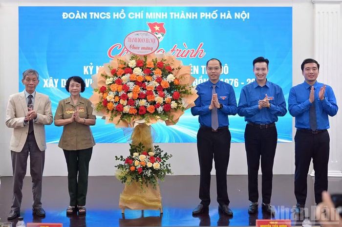Các đồng chí trong Ban Thường vụ Đoàn Thanh niên thành phố Hà Nội (bên phải) tặng hoa chúc mừng Hội Cựu thanh niên xung phong tiền trạm của Hà Nội. (Ảnh: LINH PHAN)