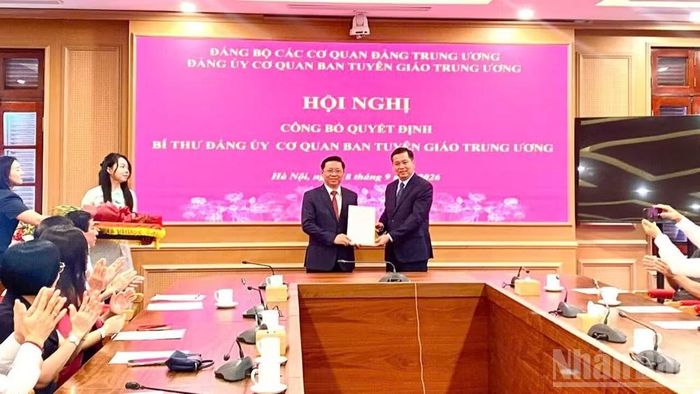 Đồng chí Nguyễn Long Hải trao Quyết định của Ban Thường vụ Đảng ủy các cơ quan Đảng Trung ương cho đồng chí Trần Thanh Lâm. (Ảnh: QUỲNH CHI)