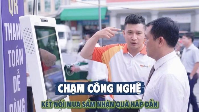 Cán bộ ngân hàng hướng dẫn người dân địa phương cài đặt và thao tác ứng dụng thanh toán di động an toàn. (Ảnh: MAI HUYÊN-THU HẰNG)