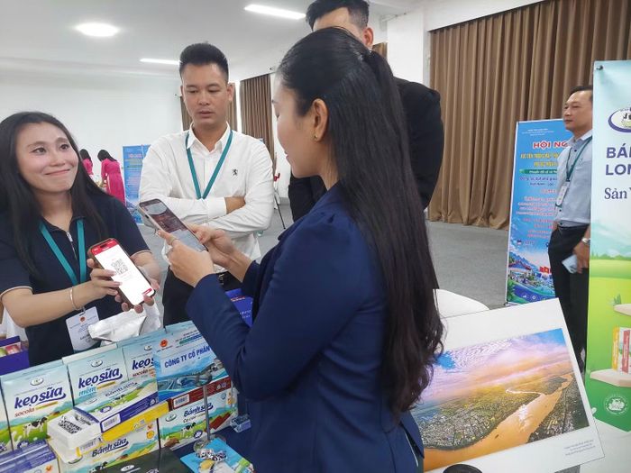 Người dân địa phương trải nghiệm thanh toán không dùng tiền mặt nhanh chóng, tiện lợi khi mua sắm đặc sản Điện Biên. (Ảnh: MAI HUYÊN-THU HẰNG)