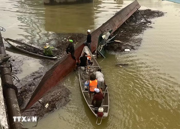 Sà lan bị chìm tại chân cầu Mỹ Chánh được lực lượng cứu hộ dùng cần cẩu kéo nổi, trục vớt an toàn. Ảnh: TTXVN