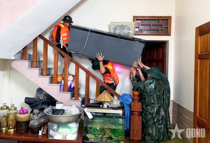 Bộ đội giúp người dân di chuyển tài sản, vật dụng lên vị trí cao, hạn chế thiệt hại do ngập lụt. 