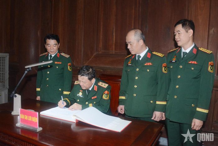 Trung tướng Bùi Trọng Vĩnh thay mặt Đoàn đại biểu Cục Bảo vệ an ninh Quân đội ghi sổ lưu niệm tại lễ báo công.