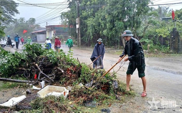 Các cán bộ, chiến sĩ giúp nhân dân dọn dẹp sau mưa lũ.