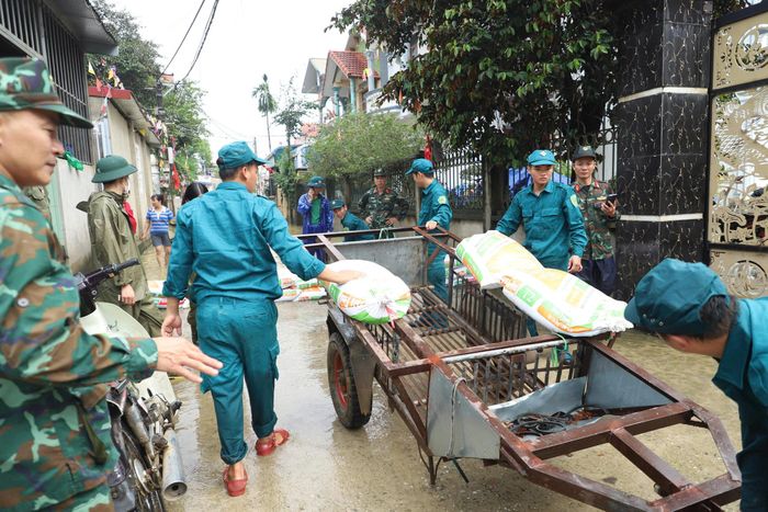 Chính quyền địa phương, cán bộ, chiến sĩ quân đội và lực lượng dân quân được huy động giúp người dân ứng phó với ngập lụt. Ảnh: TIẾN CƯỜNG