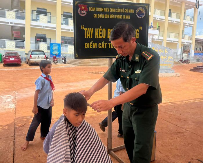  Cán bộ Đồn Biên phòng Ia Nan cắt tóc cho các em học sinh. Ảnh: NT 