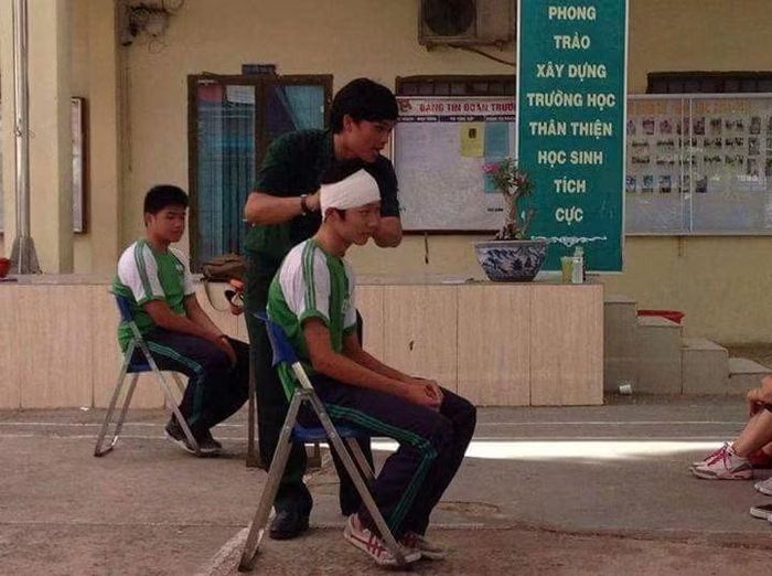 Thầy Phạm Văn Sơn - Giáo dục An ninh - Quốc phòng, THPT Phan Đăng Lưu đang hướng dẫn thao tác băng bó vết thương vùng đầu trong một buổi thực hành
