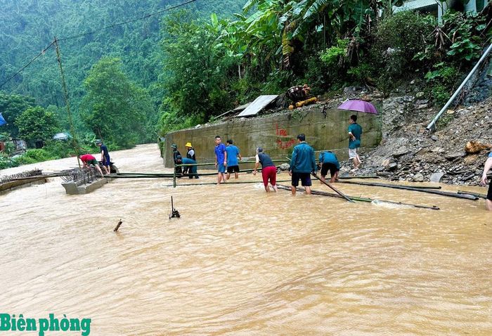 Đồn Biên phòng Tam Hợp, Bộ đội Biên phòng tỉnh Nghệ An phối hợp với dân quân, giáo viên và nhân dân địa phương làm cầu tạm, tạo điều kiện thuận lợi cho việc vận chuyển, đưa cơm đến trường cho học sinh trong thời gian tuyến đường bị chia cắt. Ảnh: Lê Thạch
