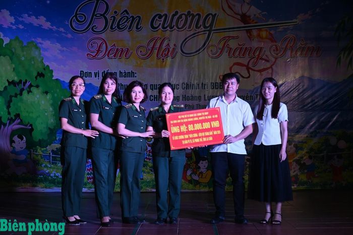 Thừa uỷ quyền của Hội Phụ nữ cơ quan Cục Chính trị Bộ đội Biên phòng và gia đình anh chị Đặng Hoàng Lương, Nguyễn Thị Hoài (Hà Nội), Hội Phụ nữ Bộ đội Biên phòng tỉnh Lai Châu trao biển tượng trưng ủng hộ chương trình 80 triệu đồng. Ảnh: Đức Duẩn