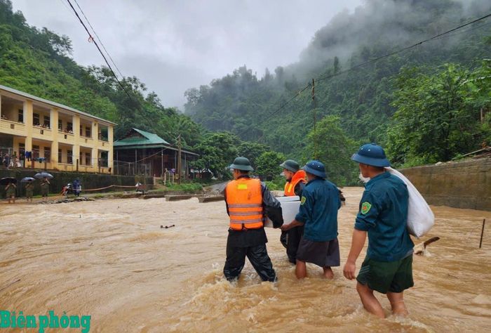 Cán bộ Đồn Biên phòng Tam Hợp, Bộ đội Biên phòng tỉnh Nghệ An và Ban Chỉ huy Quân sự xã Tam Thái vượt dòng nước lũ, mang cơm đến cho học sinh tại khu vực bị chia cắt. Ảnh: Lê Thạch