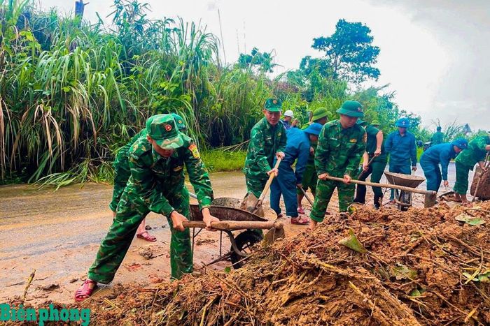 Cán bộ, chiến sĩ Đồn Biên phòng Ba Tầng, Bộ đội Biên phòng tỉnh Quảng Trị phối hợp với các lực lượng tại địa phương khẩn trương thu dọn đất đá tại điểm sạt lở, sớm khơi thông tuyến đường. Ảnh: Thành Phú