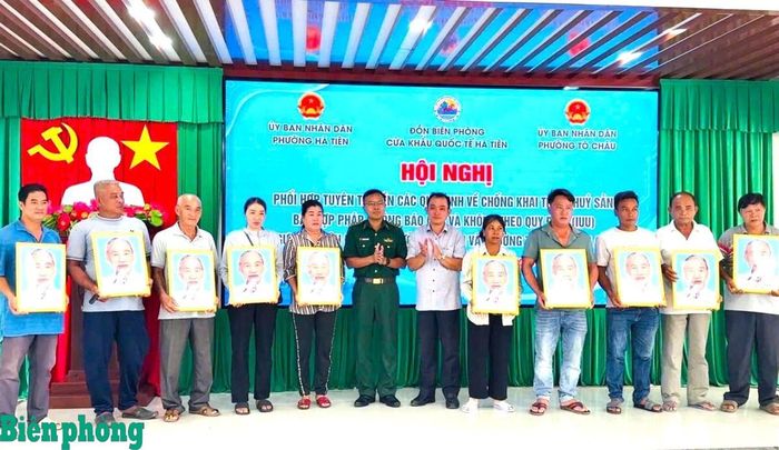 Thượng tá Nguyễn Tấn Dương, Đồn trưởng Đồn Biên phòng cửa khẩu quốc tế Hà Tiên trao tặng ảnh Bác Hồ cho ngư dân. Ảnh: Thu Ngân