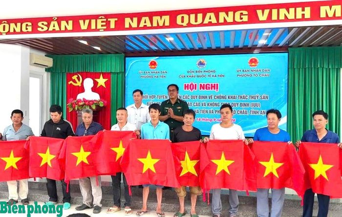 Thiếu tá La Minh Nhòa, Chính trị viên phó Đồn Biên phòng cửa khẩu quốc tế Hà Tiên trao tặng cờ Tổ quốc cho ngư dân. Ảnh: Thu Ngân