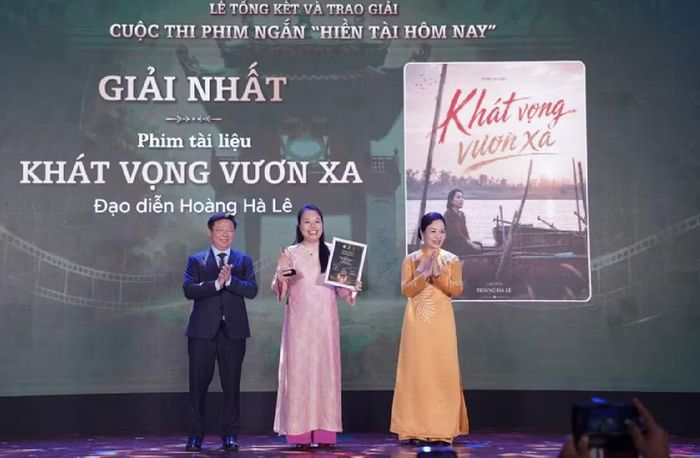 Phó Trưởng ban Thường trực Ban Tuyên giáo Trung ương Trần Thanh Lâm (bìa trái) và Chủ tịch Hiệp hội Xúc tiến phát triển Điện ảnh Việt Nam Ngô Phương Lan (bìa phải) trao giải nhất cho tác giả Hoàng Hà Lê. Ảnh: BTC