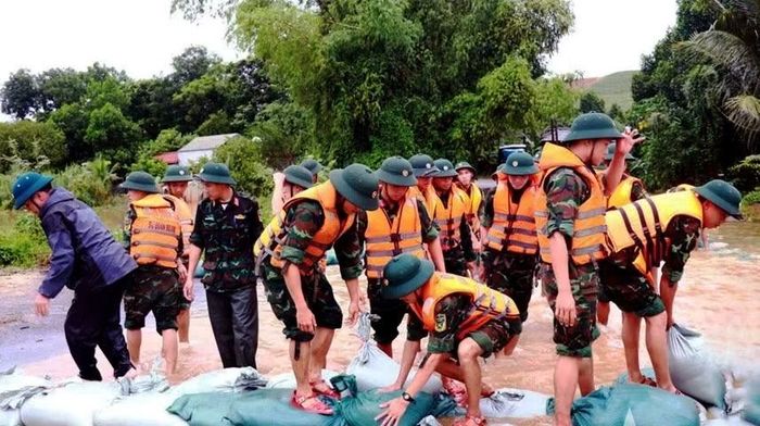 Cán bộ, chiến sĩ Quân đoàn 12 gia cố, nâng cao, chống tràn mặt đê, nhằm ứng phó, hạn chế thiệt hại do thiên tai (ảnh: Khánh Trình).