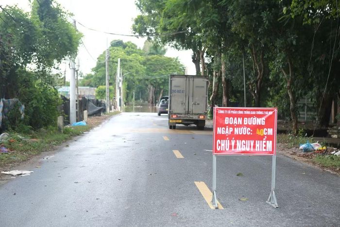 Lực lượng chức năng cắm biển cảnh báo “Đoạn đường ngập nước 40cm” để người dân lưu ý khi di chuyển qua khu vực.