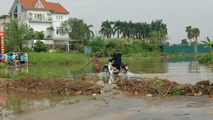 Nhiều người dân vẫn di chuyển qua khu vực ngập nước.