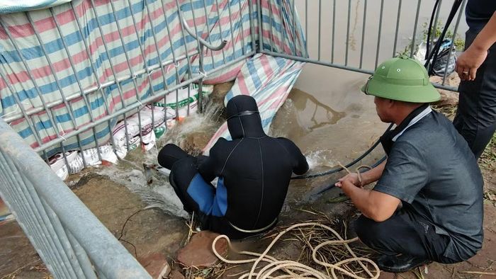 Thợ lặn xuống cống tìm kiếm.