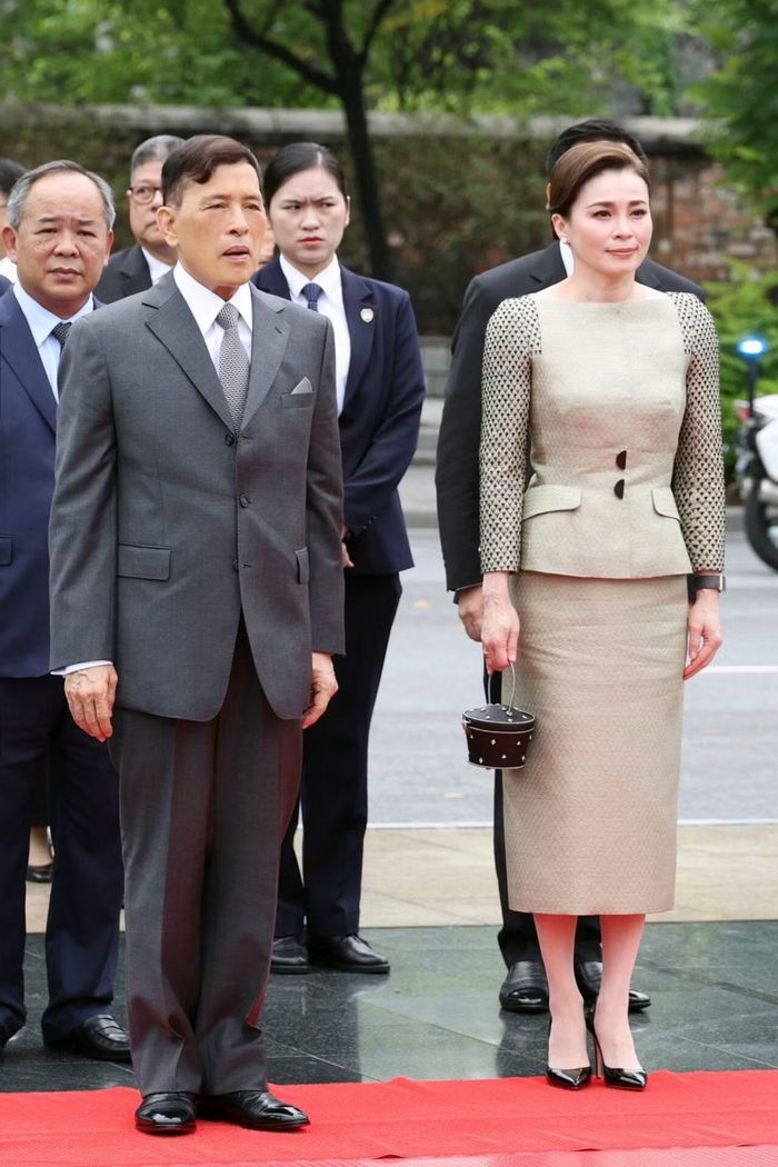 Ngày 16/9, Hoàng hậu Suthida chọn bộ trang phục đồng điệu gồm blazer và chân váy trên nền lụa dệt hoa màu xanh olive pha xám. Áo blazer có phom gọn, cổ mở, điểm hàng nút bán nguyệt và họa tiết cườm đen đính tay trên tay áo.
