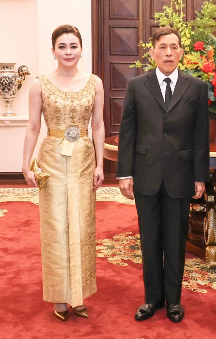 Trong buổi tiệc chiêu đãi tối 15/9 tại Hà Nội, Hoàng hậu Suthida chọn sắc vàng gold làm chủ đạo với Chud Thai Dusit mang phom dáng thanh lịch. Đai vàng dệt họa tiết Chakri và khuyên tai kim cương góp phần tạo nên tổng thể trang phục trang trọng, phù hợp với không gian buổi tiệc.