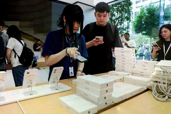 Khách hàng mua iPhone tại cửa hàng Singapore ngày 18/9. (Ảnh: Straitstimes)