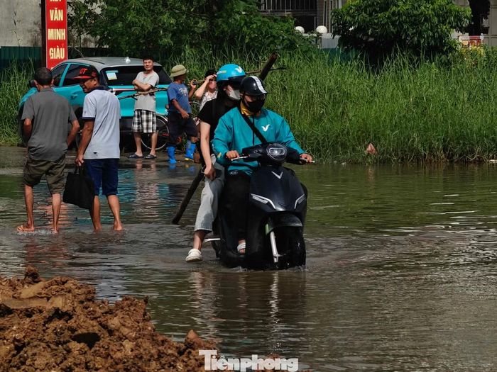 Người dân di chuyển qua khu vực ngập nước.