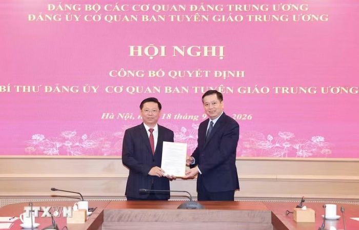 Phó Bí thư Thường trực Đảng ủy các cơ quan Đảng Trung ương Nguyễn Long Hải trao quyết định và chúc mừng ông Trần Thanh Lâm. Ảnh: TTXVN.