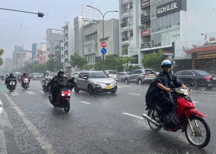 Cơn mưa lớn khiến người dân vất vả di chuyển trên đường Nam Kỳ Khởi Nghĩa (phường Xuân Hòa, TP. HCM).