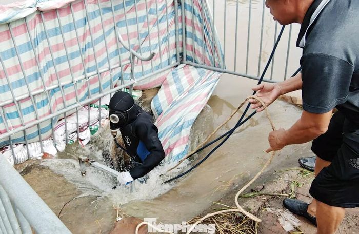 Lực lượng tìm kiếm lặn xuống cống nơi phát hiện xe máy của nam sinh.