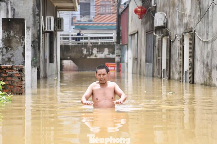 Nước dâng cao khiến việc đi lại và sinh hoạt của người dân gặp khó khăn.
