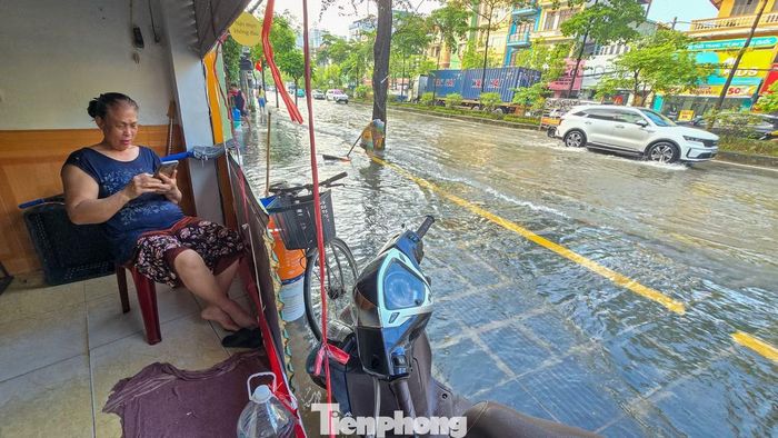 Mỗi khi xe tải, xe buýt chạy qua, sóng nước dồn mạnh về hai bên đường, khiến người dân phải liên tục gia cố các tấm chắn trước cửa.