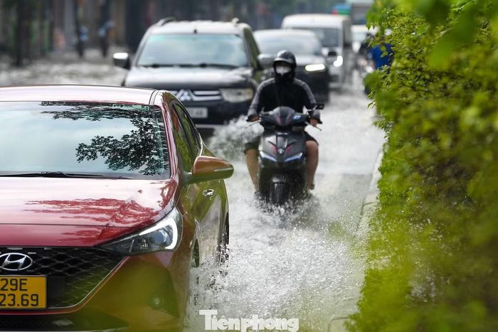 Nước phủ kín cả hai chiều quốc lộ 32, có vị trí sâu khoảng nửa mét, khiến việc đi lại của người dân gặp nhiều khó khăn.