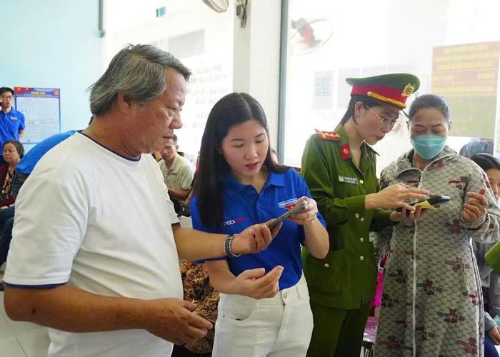Người dân trải nghiệm các tiện ích số và được hướng dẫn sử dụng VNeID tại điểm hỗ trợ. (Ảnh: CA)