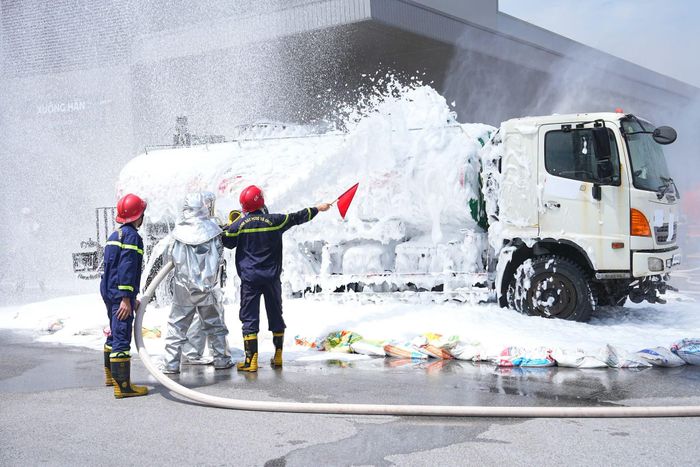 Lực lượng chức năng triển khai phương án xử lý sự cố cháy xe bồn bằng bọt chữa cháy.
