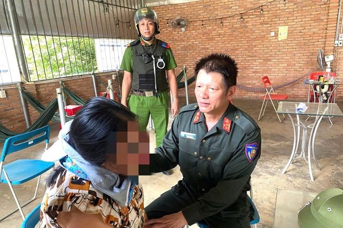 Thượng tá Nguyễn Công An (phải), khuyên người phụ nữ từ bỏ ý định tự tử. Ảnh: CA