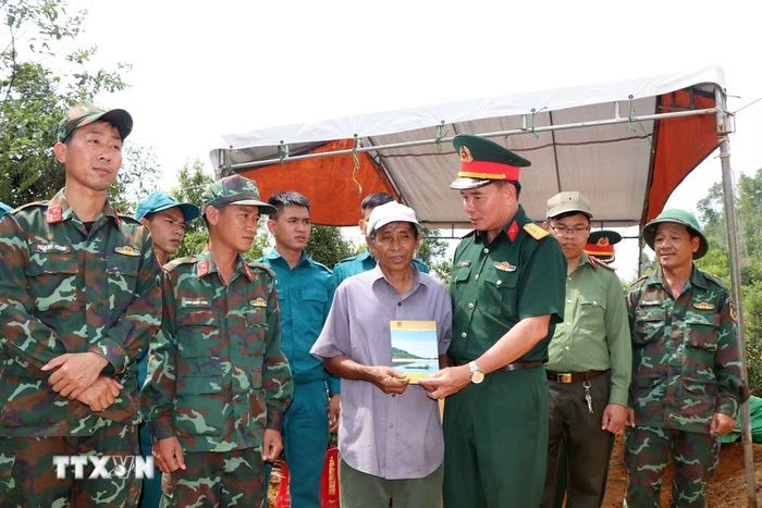 Đại tá Trịnh Công Sơn, Phó Chính ủy Bộ Chỉ huy Quân sự tỉnh Quảng Ngãi thăm hỏi lực lượng tham gia tìm kiếm, quy tập hài cốt liệt sỹ ở đồi Sim, xã Đặng Thùy Trâm. (Ảnh: Cao Nguyên/TTXVN)