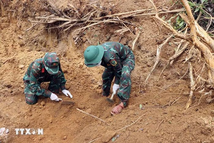Ngoài máy móc, Lực lượng vũ trang tỉnh Quảng Ngãi kết hợp phương pháp thủ công để tìm kiếm hài cốt liệt sỹ trên đồi Sim, xã Đặng Thùy Trâm. (Ảnh: Cao Nguyên/TTXVN)